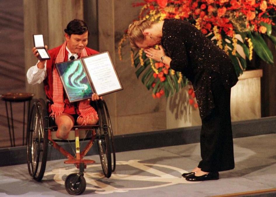 The winner of the Nobel Peace Prize Jody Williams bows in front of Cambodian Tun Channereth, who holds the International Campaign to Ban Landmines diploma and medal, on her way to receive the Nobel Peace Prize in Oslo City Hall, December 10, 1997.