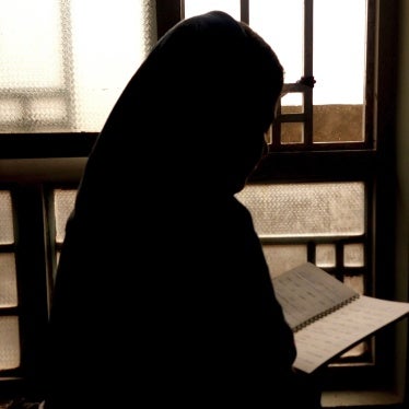 A 15-year-old girl reads out of a notebook because she is barred from attending school in Kabul, Afghanistan, March 2024.