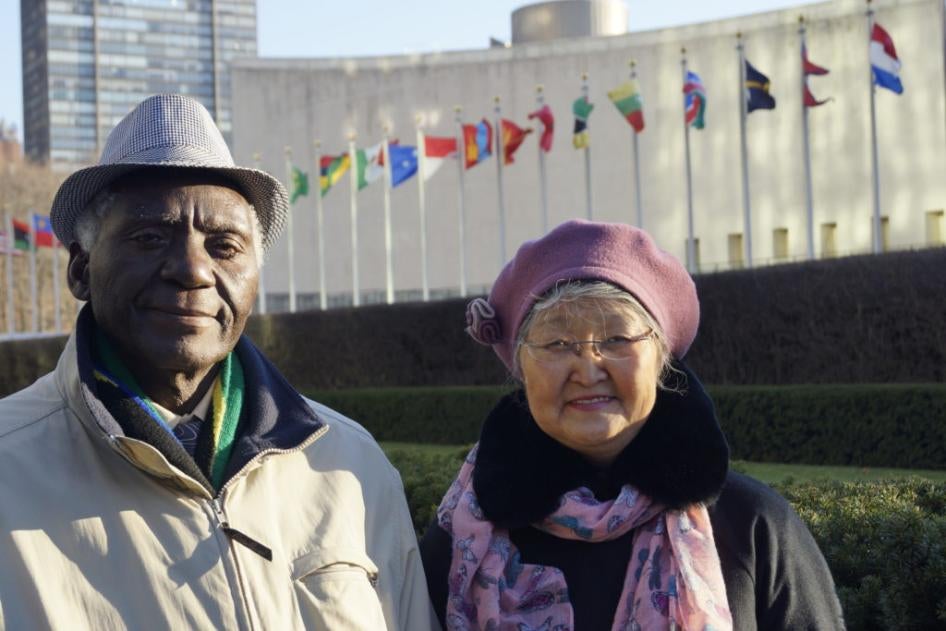 A man and woman pose in front of the United Nations