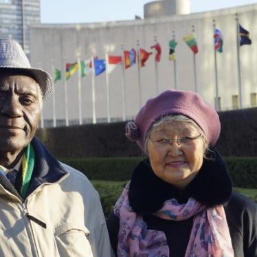 A man and woman pose in front of the United Nations