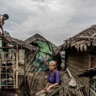 A Rohingya man fixes his roof