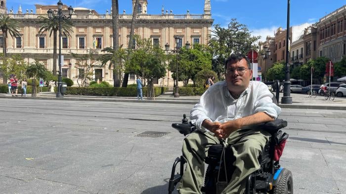 Carlos Reina Rosales, 35, sits in his electric wheelchair, in front of a museum in central Seville (Andalusia, Spain). 