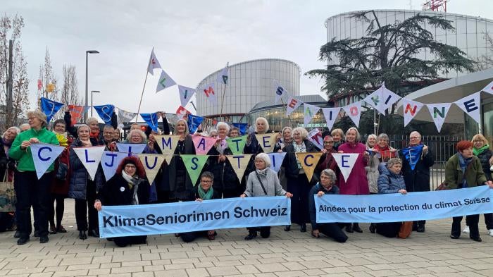 A group from the Senior Women for Climate Protection association hold banners outside the European Court of Human Rights in Strasbourg, France.