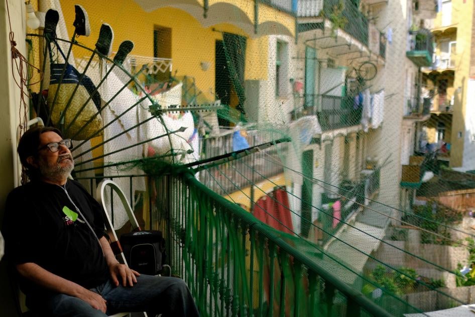 Fernando Uceta, who has COPD, uses a portable oxygen concentrator to breathe as he sits on the balcony of his home during the summer heatwave, in Barcelona's Raval neighbourhood, Spain, June 27, 2023.