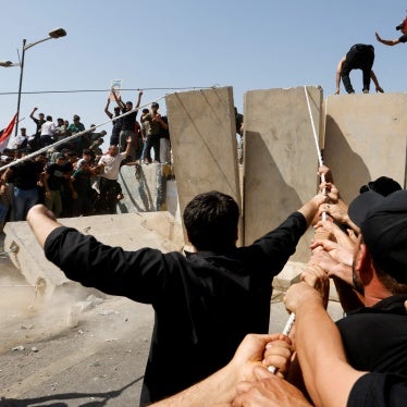 Supporters of Iraqi Shi'ite cleric Moqtada al-Sadr pull down a concrete barrier during a protest against corruption, in Baghdad, Iraq, July 30, 2022.