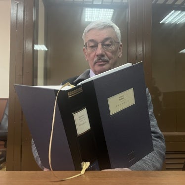 Oleg Orlov reading Franz Kafka’s The Trial in a Moscow courtroom during his trial, February 2024. 