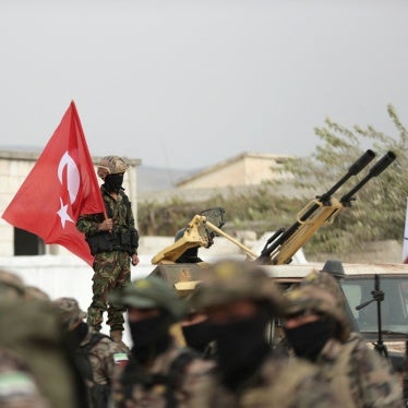 An unidentifiable soldier holds a Turkish flag