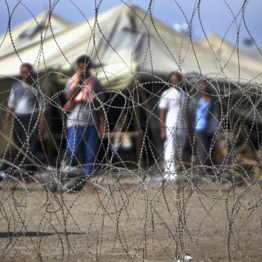 Prisoners stand next to the tents in which they are housed at the Abu Ghraib prison west of Baghdad, Iraq, July 15, 2004.