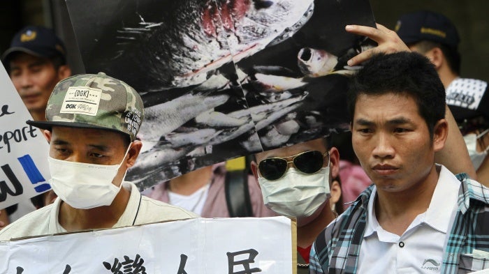 Vietnamese activists hold a photo of dead fish allegedly killed with toxic chemicals during a protest to urge Formosa Plastics Group to take responsibility for the cleanup in Vietnam, August 10, 2016, in Taipei, Taiwan.