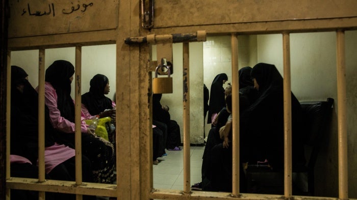 Women and children wait in a holding cell