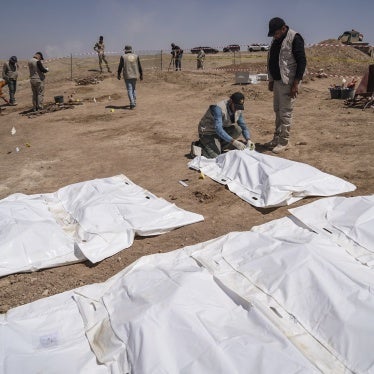 Members of expert teams take part in the opening of a mass grave and the exhumation of the remains of victims who were killed and buried by the so-called Islamic State (ISIS) terror group back in 2014, in Al-Humaydat, Iraq, June 13, 2021.