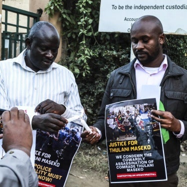 Activists light candles while holding posters at a tribute to the assassinated human rights lawyer Thulani Maseko, Eswatini, formerly Swaziland