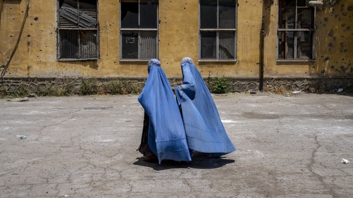 Afghan women wait to receive food rations distributed by a humanitarian aid group, in Kabul, Afghanistan, on May 28, 2023.