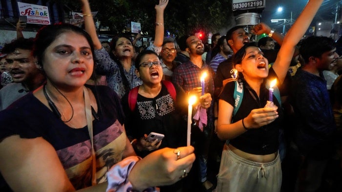 Protesters hold signs and candles 