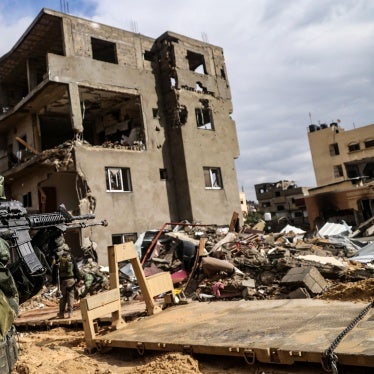 An Israeli soldier aims his weapon in front of a destroyed building in Khan Yunis in southern Gaza on January 27, 2024.