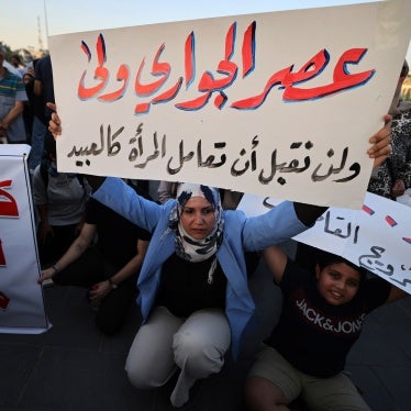 A woman holds a sign protesting women being deprived of their rights in marriage in Tahrir Square, Baghdad, Iraq, August 8, 2024.